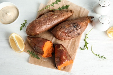 Photo of Flat lay composition with baked sweet potatoes on white table