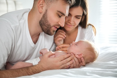 Happy couple with their newborn baby at home