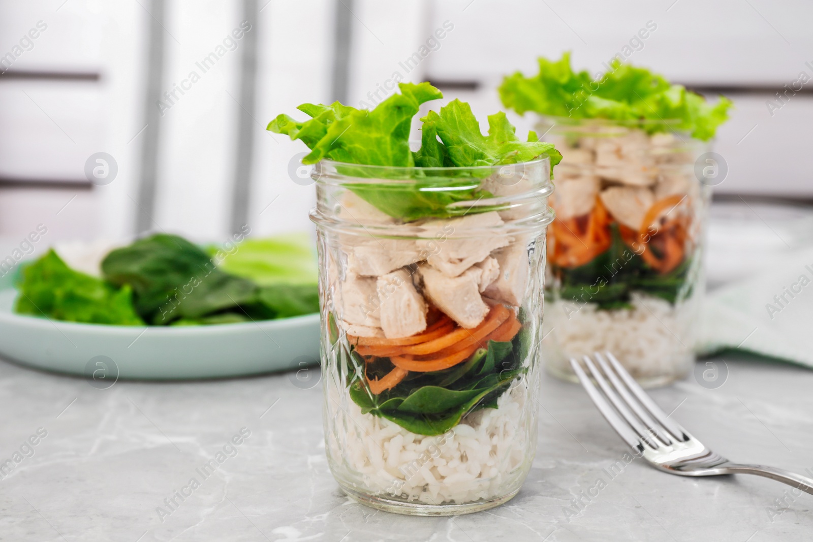 Photo of Healthy salad in glass jars on marble table