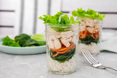 Photo of Healthy salad in glass jars on marble table