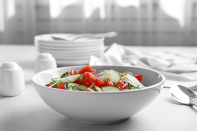 Photo of Delicious fresh cucumber tomato salad in bowl on table