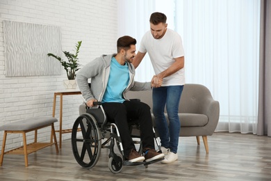 Photo of Volunteer helping man in wheelchair at home