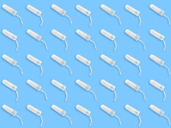 Many tampons on light blue background, flat lay 