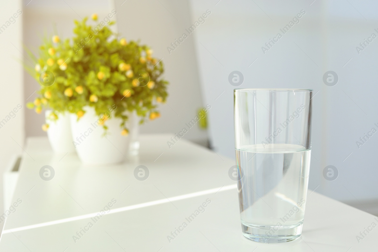 Photo of Glass of water on table indoors. Space for text