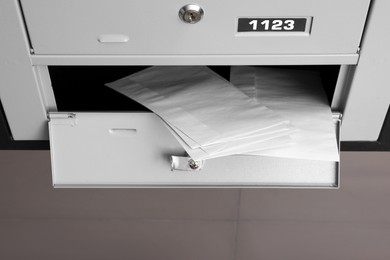 Photo of Open metal mailbox with envelopes indoors, above view