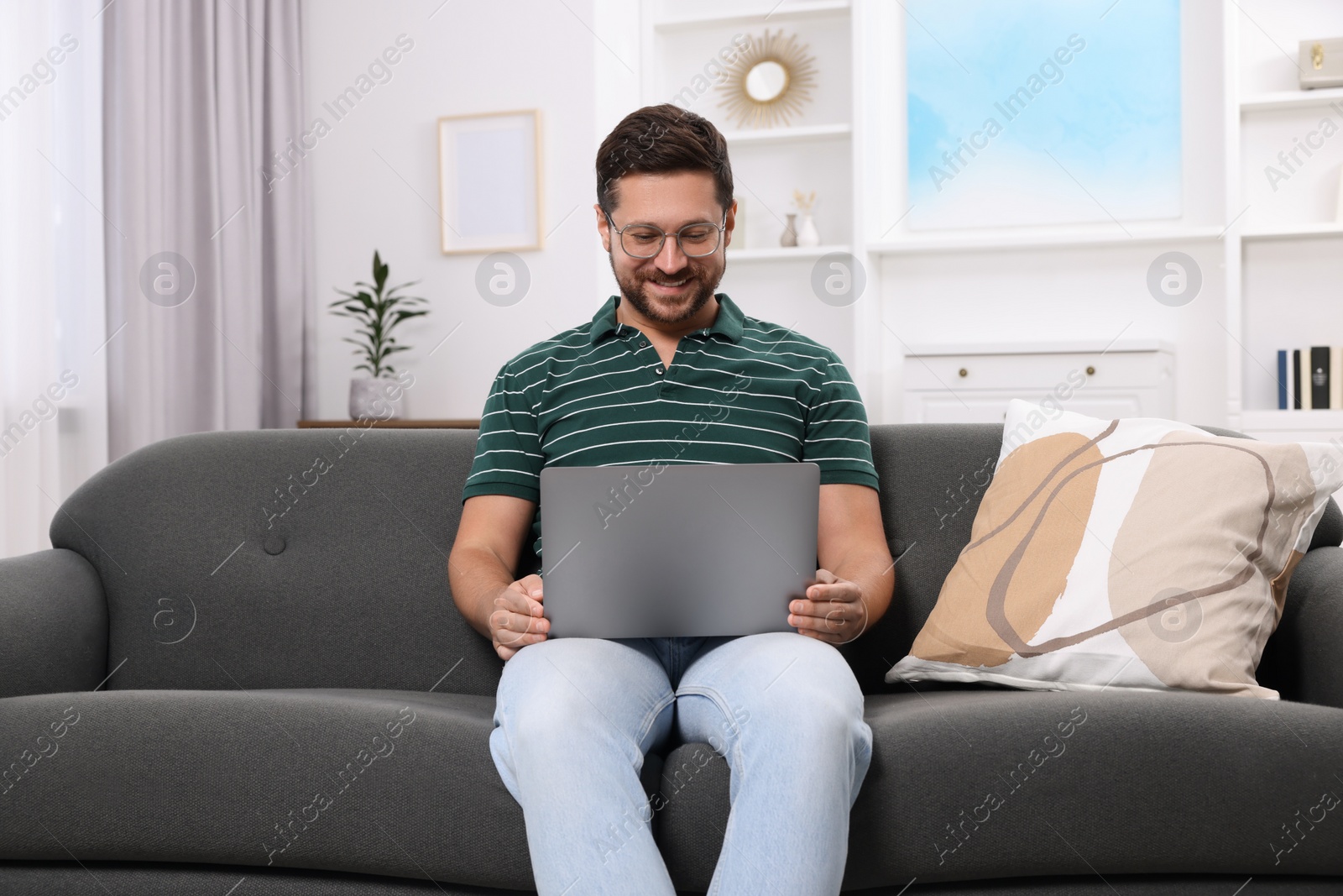 Photo of Happy man having video chat via laptop at home