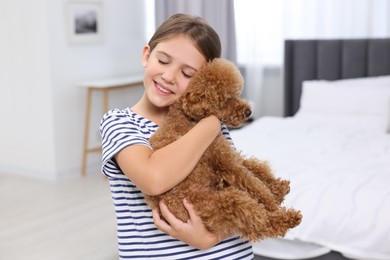 Photo of Little child with cute puppy in bedroom. Lovely pet