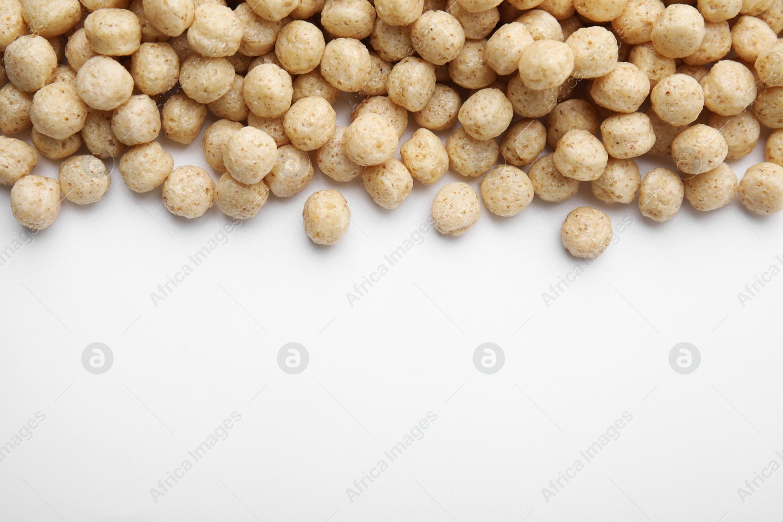 Photo of Tasty cereal balls on white background, flat lay