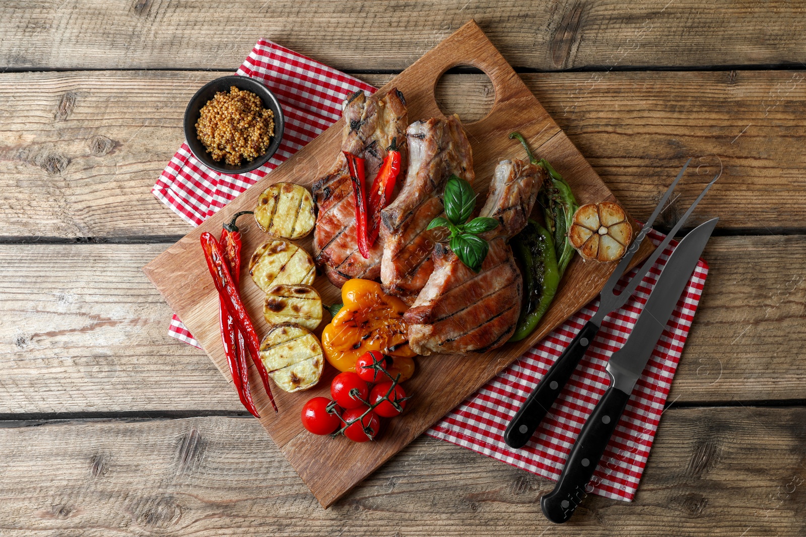 Photo of Delicious grilled meat and vegetables served on wooden table, flat lay