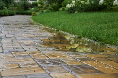 Photo of Puddle after rain on street tiles outdoors