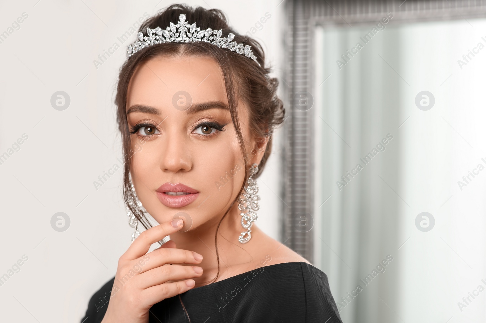 Photo of Beautiful young woman wearing luxurious tiara indoors, space for text