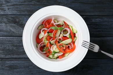 Photo of Plate with delicious fresh salad on table, top view