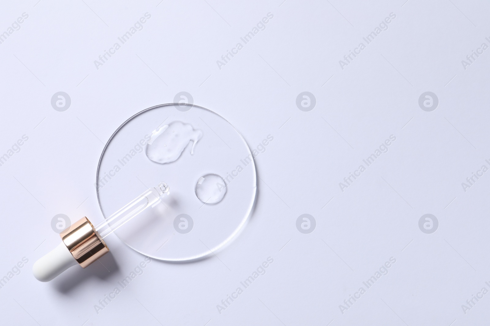 Photo of Samples of cosmetic serum and pipette on white background, top view. Space for text