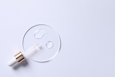 Samples of cosmetic serum and pipette on white background, top view. Space for text