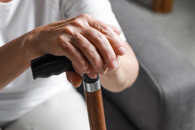 Photo of Elderly woman with walking cane indoors, closeup. Home care service