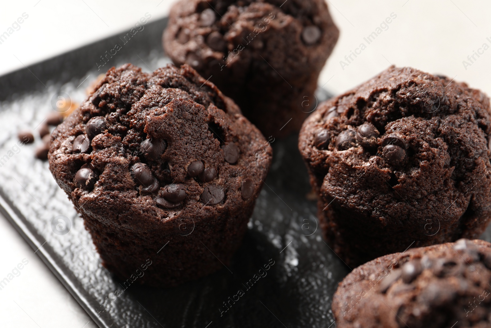 Photo of Delicious chocolate muffins on light table, closeup