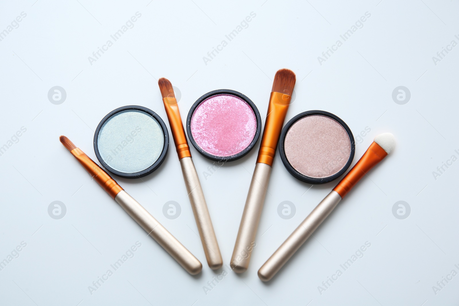 Photo of Makeup brushes with cosmetics on white background