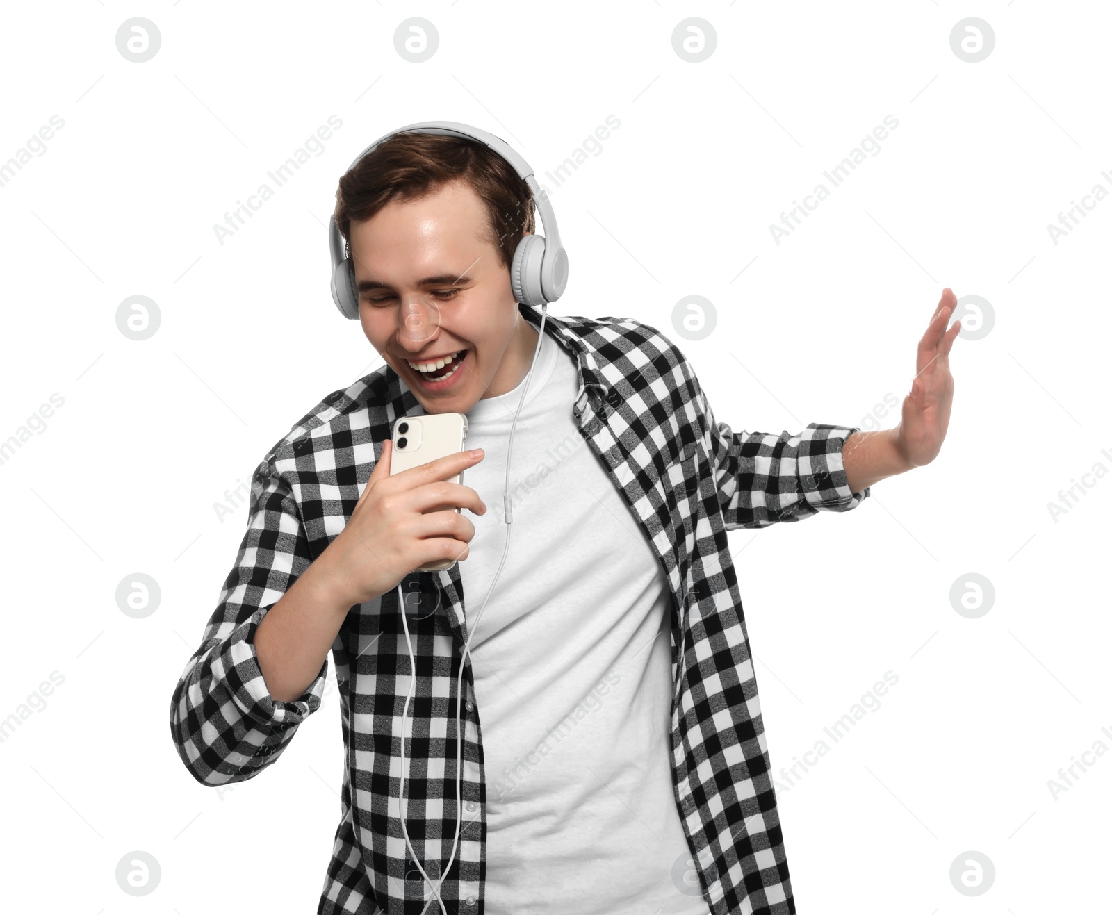 Photo of Handsome young man with headphones and smartphone singing on white background