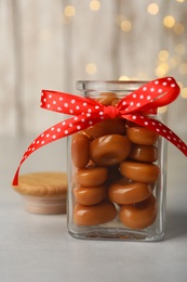 Photo of Sweet candies in jar on light grey table