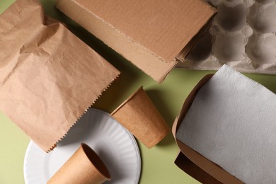 Photo of Heap of waste paper on pale green background, flat lay