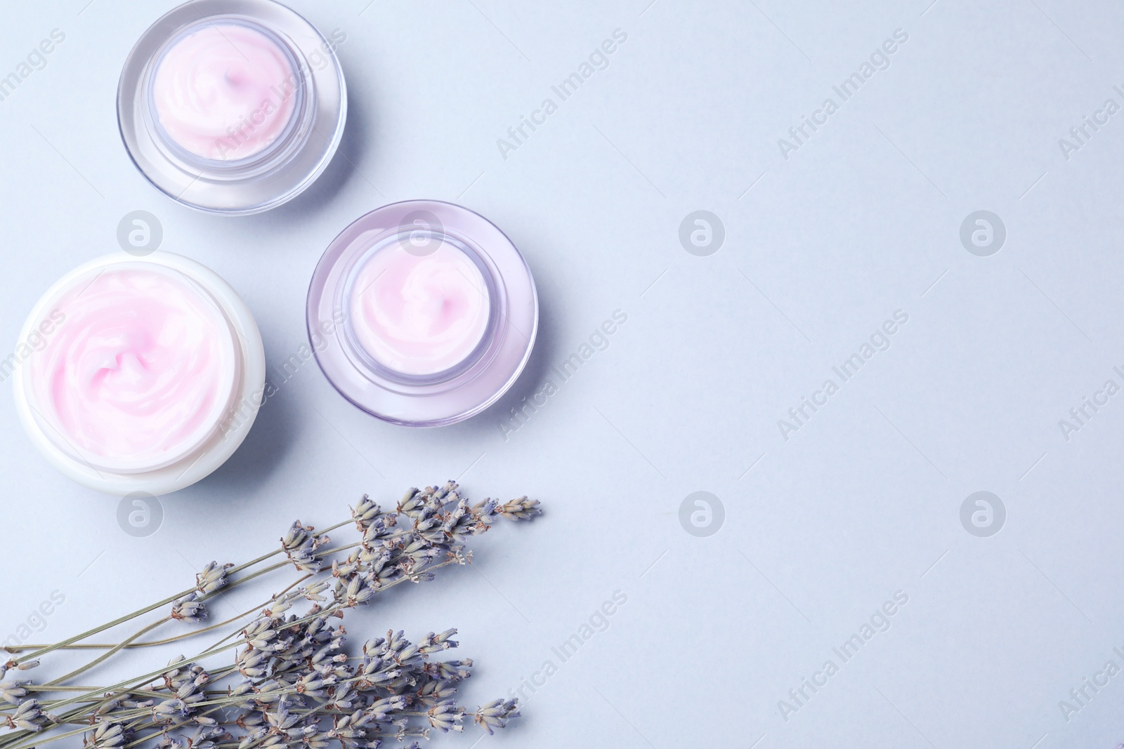 Photo of Flat lay composition with jars of cream on white background. Space for text