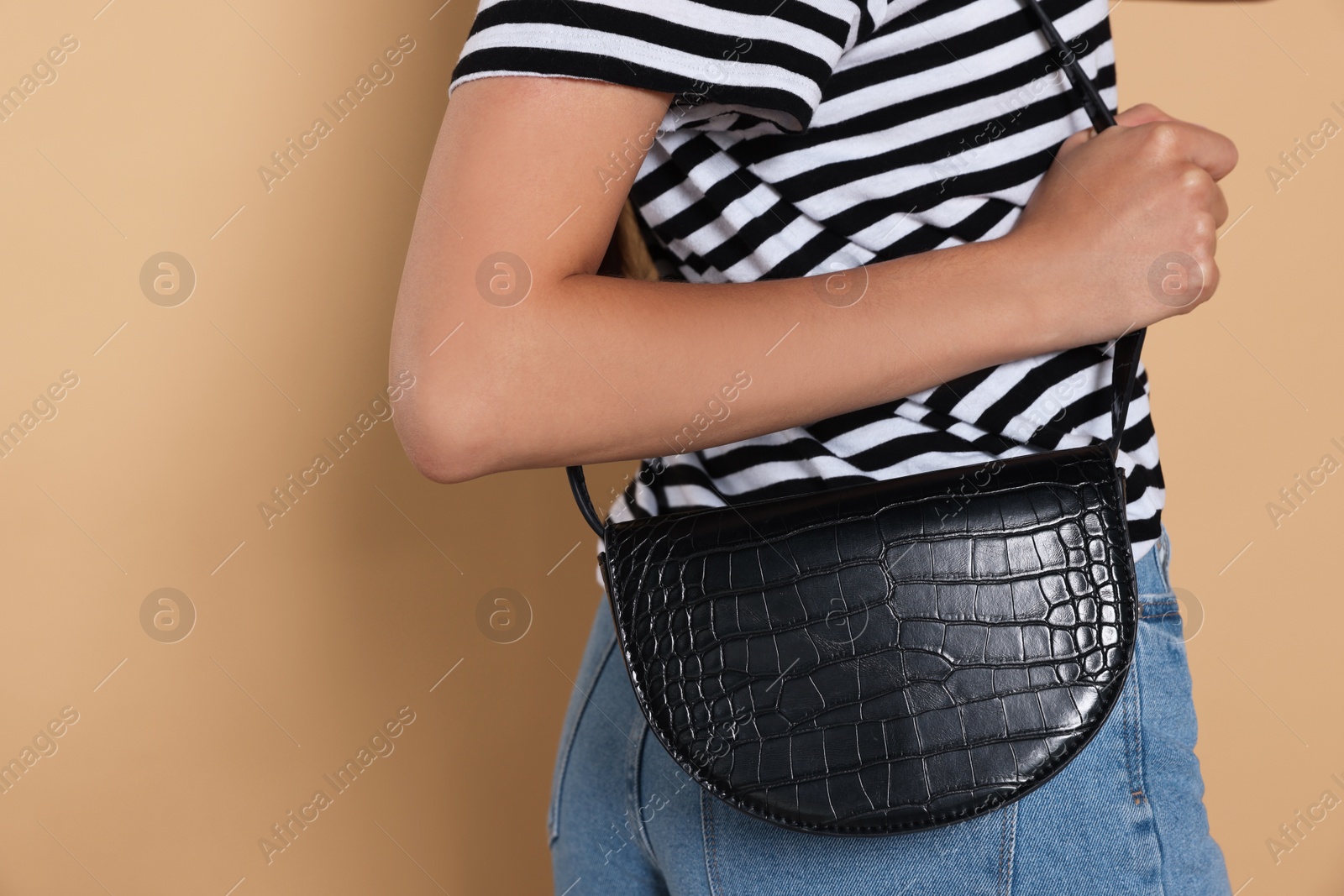 Photo of Woman with stylish bag on beige background, closeup