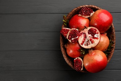 Delicious ripe pomegranates on grey wooden table, top view. Space for text