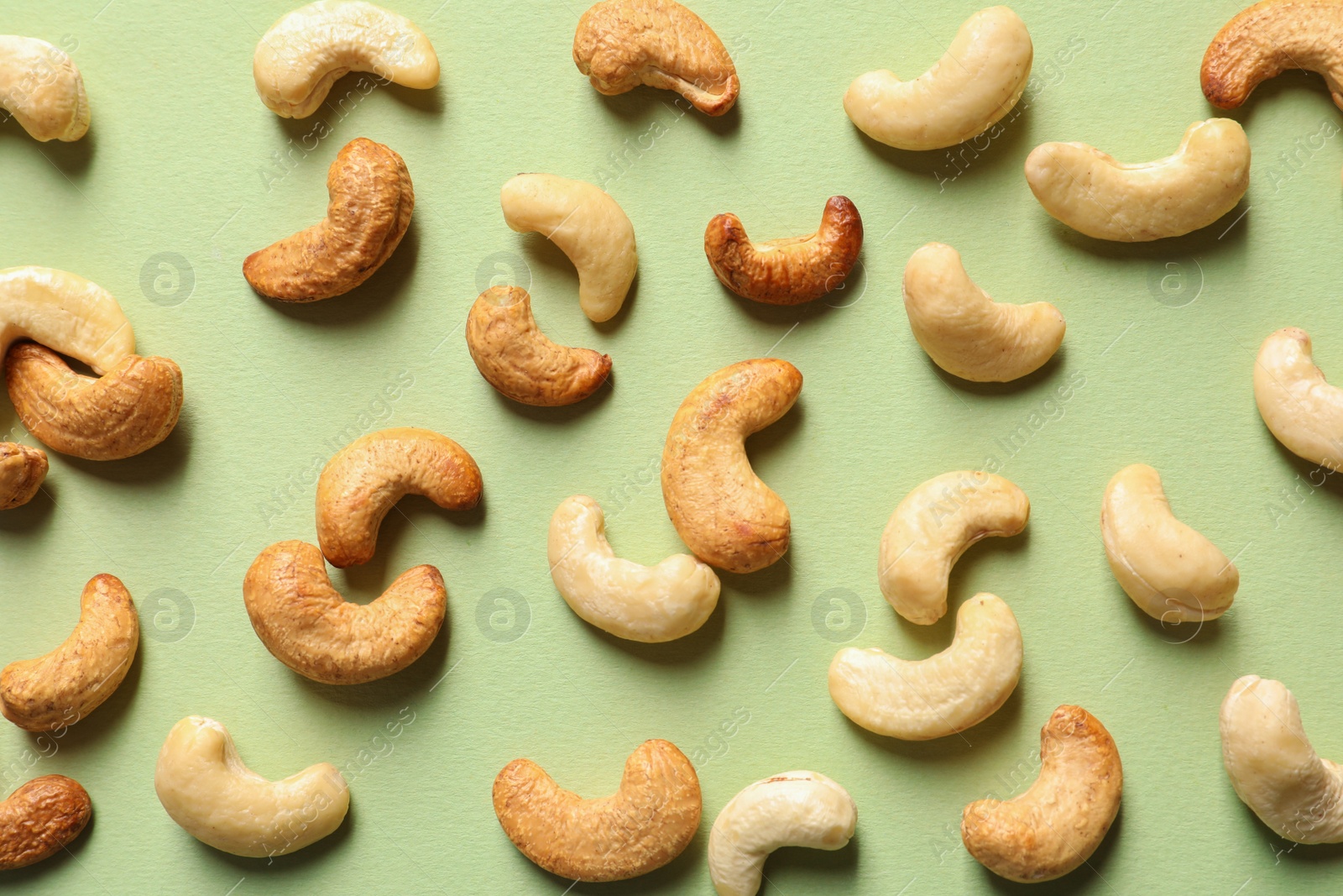 Photo of Tasty cashew nuts on color background, flat lay