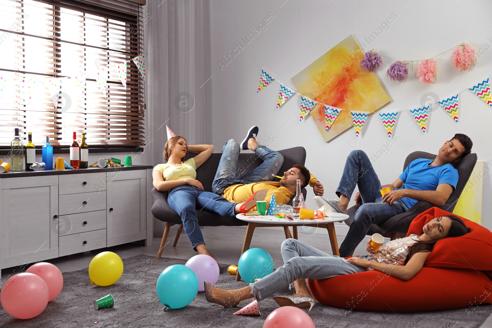 Photo of Group of friends sleeping in messy room after party