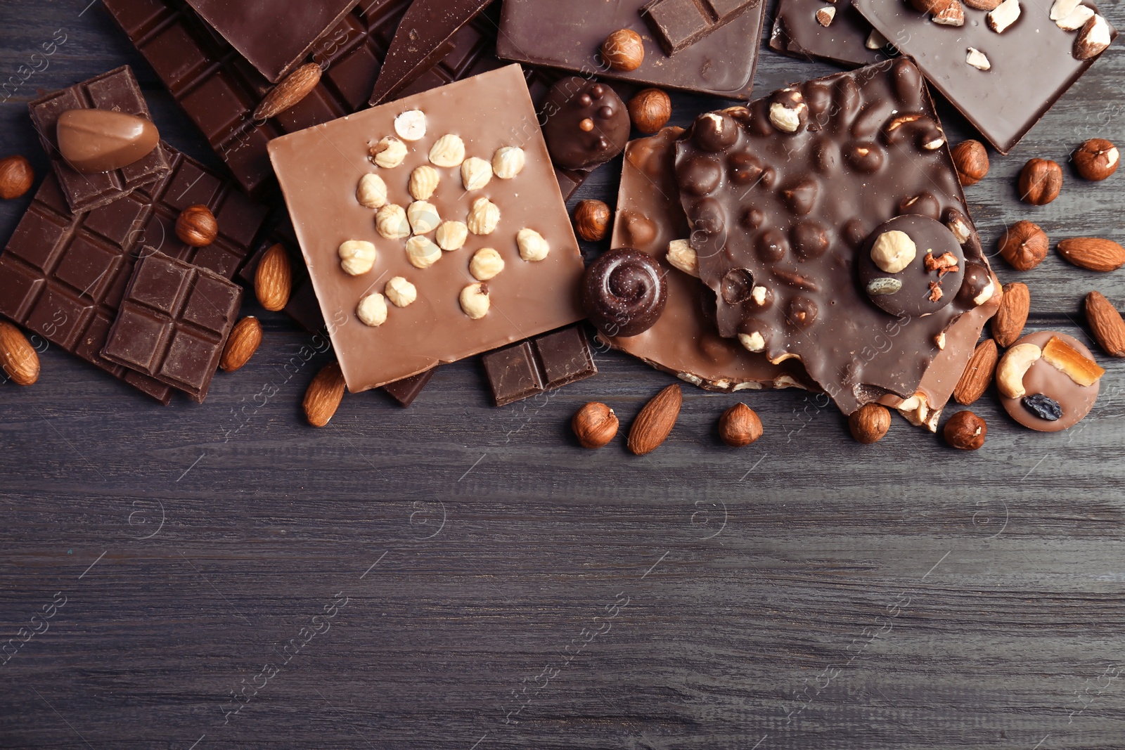 Photo of Different delicious chocolate bars and candies on wooden table, top view