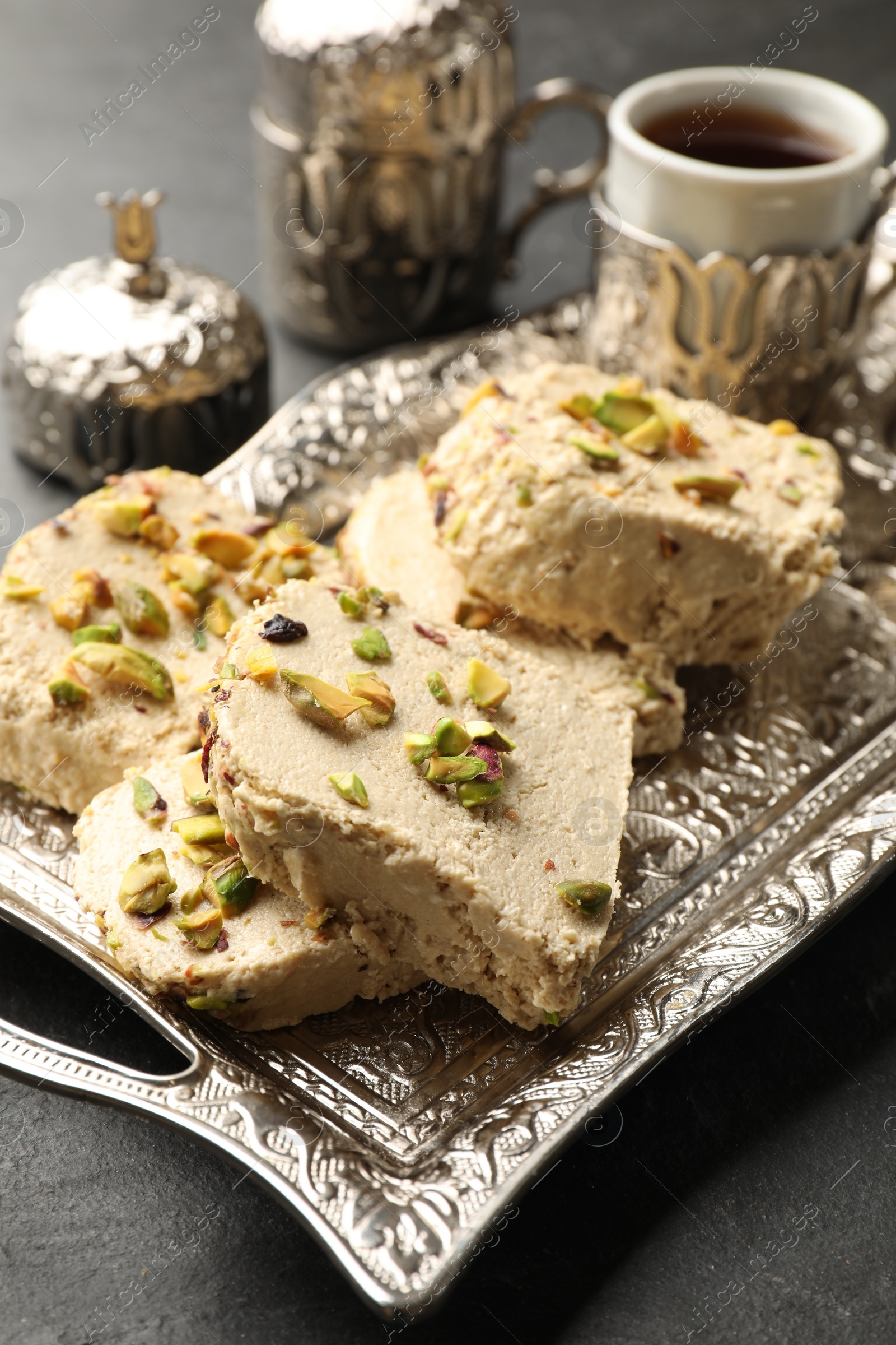 Photo of Tasty pistachio halva served on grey table, closeup