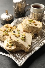 Photo of Tasty pistachio halva served on grey table, closeup