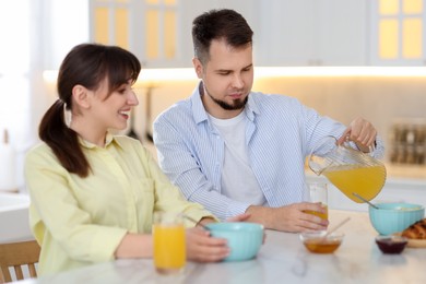 Photo of Happy couple having tasty breakfast at home