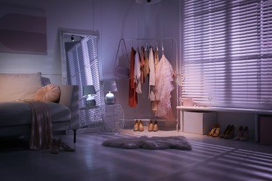 Photo of Modern dressing room interior with clothing rack and mirror