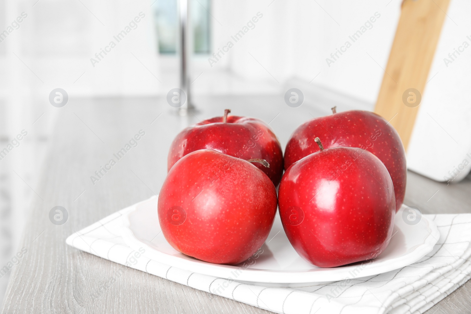 Photo of Ripe juicy red apples on white wooden table indoors