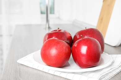 Ripe juicy red apples on white wooden table indoors