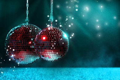 Shiny disco balls on dark cyan background with blurred lights, space for text. Bokeh effect