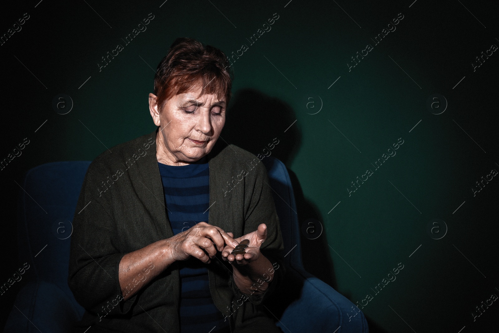 Photo of Poor senior woman with coins on color background. Space for text