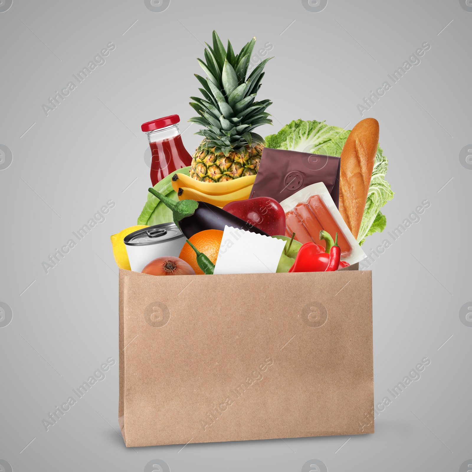 Image of Paper bag with different products and receipt on grey background