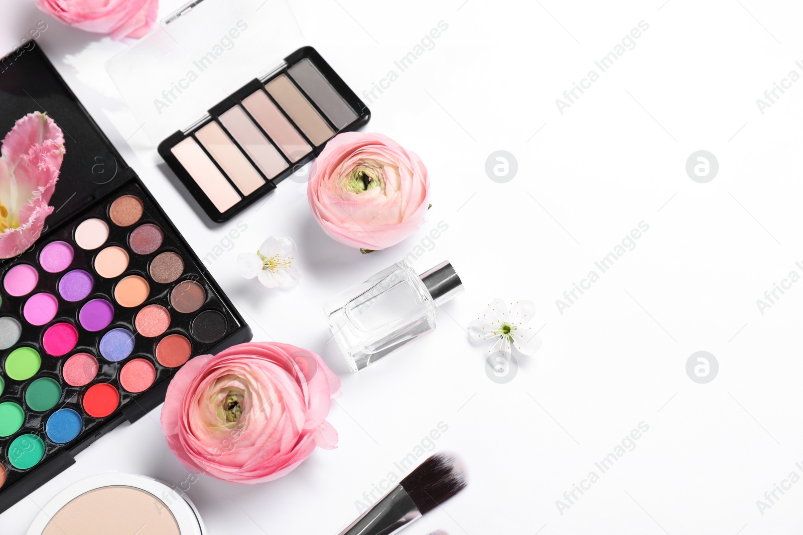 Photo of Flat lay composition with different makeup products and beautiful spring flowers on white background, space for text