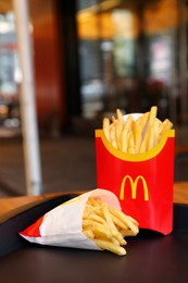 Photo of MYKOLAIV, UKRAINE - AUGUST 11, 2021: Big and small portions of McDonald's French fries on tray in cafe