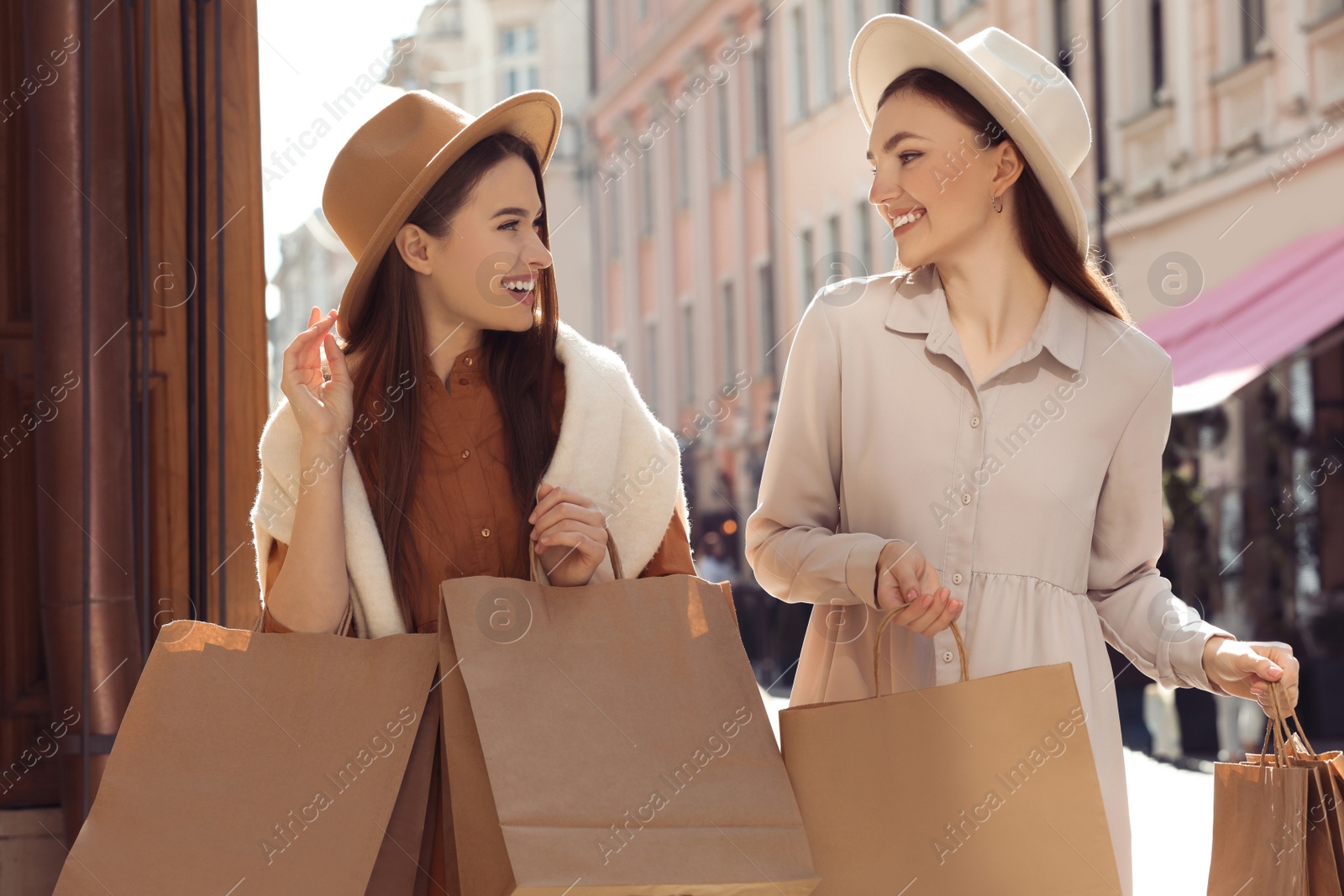 Photo of Beautiful young women with shopping bags on city street