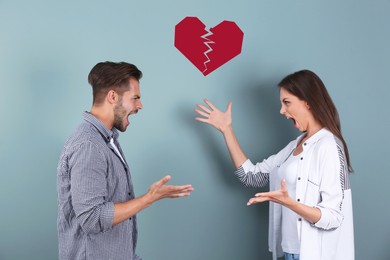 Young couple having argument and illustration of broken heart on color background. Relationship problems