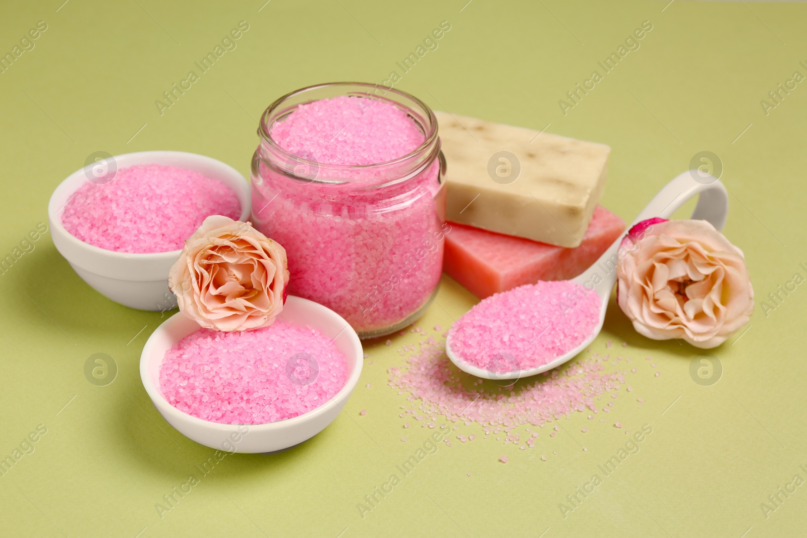 Photo of Aromatic sea salt and beautiful flowers on pale green background