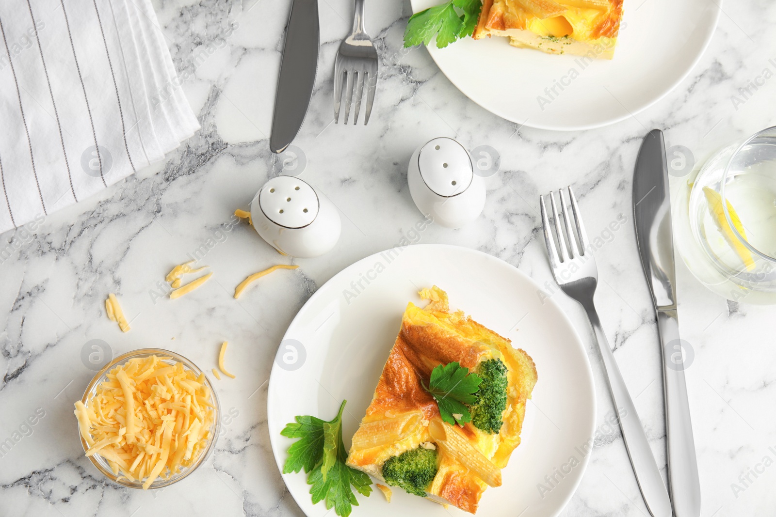 Photo of Tasty broccoli casserole served on white marble table, flat lay