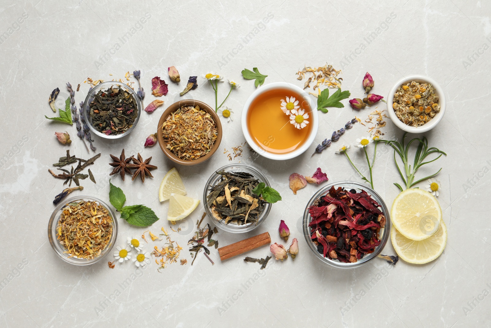 Photo of Flat lay composition with fresh brewed tea and dry leaves on light table