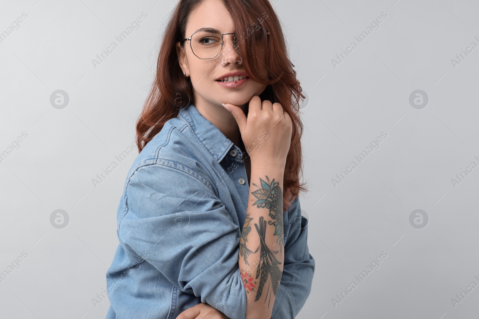 Photo of Portrait of beautiful tattooed woman on gray background