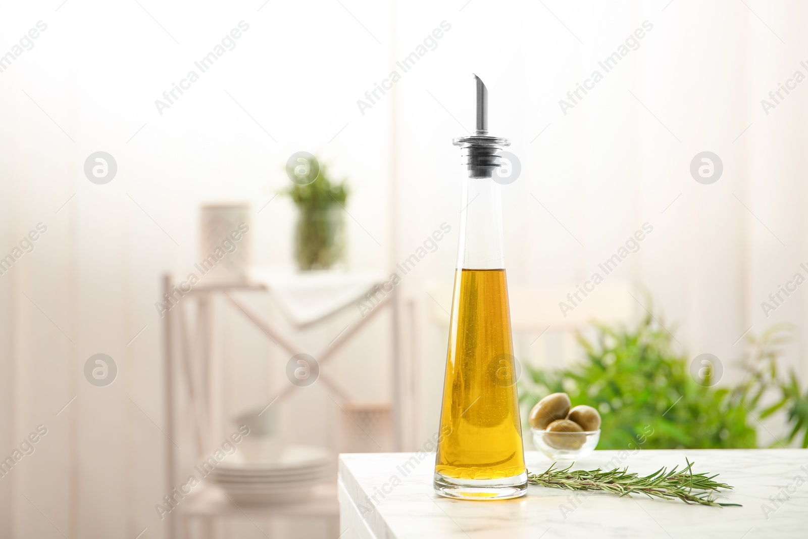 Photo of Bottle with fresh rosemary oil on table