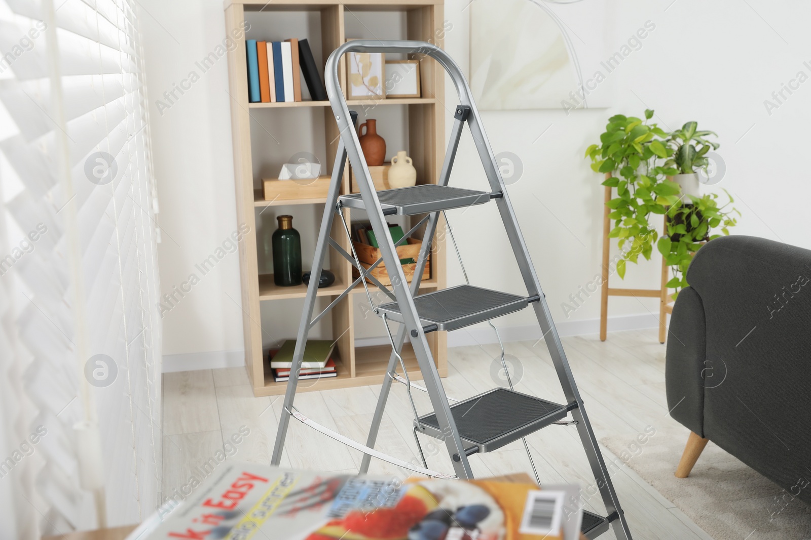 Photo of Metal folding ladder in stylish living room