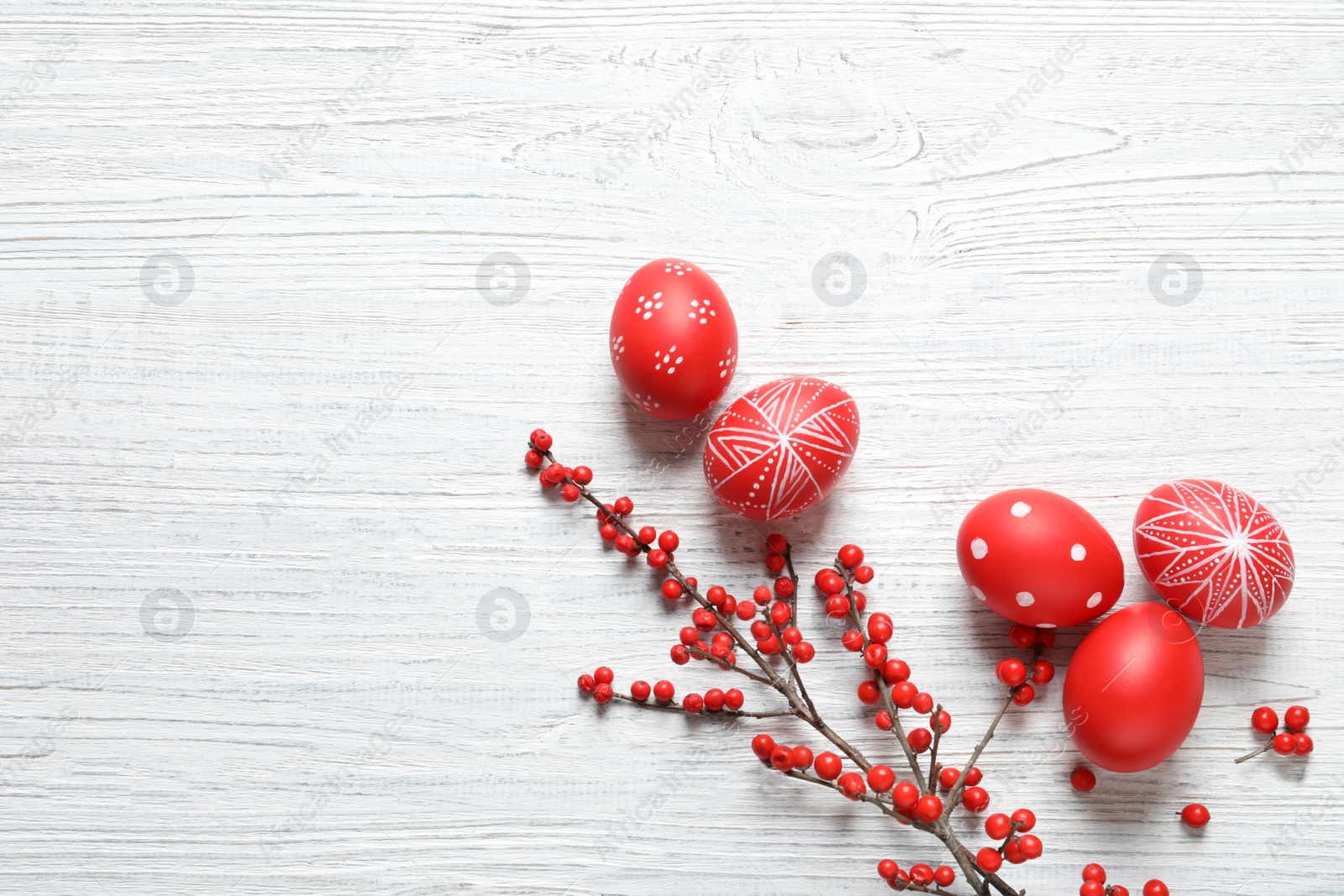 Photo of Flat lay composition with painted Easter eggs on wooden table, space for text